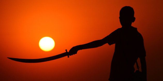 RAJASTHAN, INDIA - 2015/11/19: A child standing with a sword in hand during the sunset at the annual cattle fair in Pushkar, western Rajasthan state. Pushkar is a popular Hindu pilgrimage spot that is also frequented by foreign tourists who come to the town for its annual cattle fair. (Photo by Shaukat Ahmed/Pacific Press/LightRocket via Getty Images)