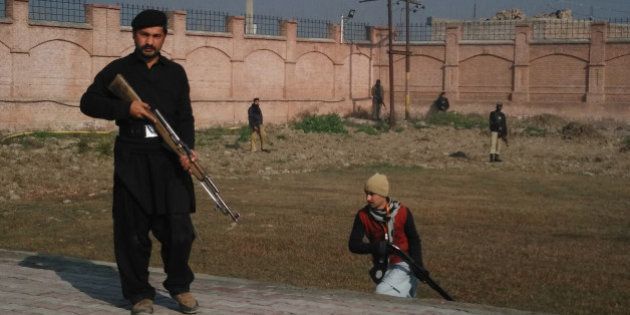 This photograph taken from a mobile phone shows Pakistani security personnel taking position outside the Bacha Khan university following an attack by gunmen in Charsadda, about 50 kilometres from Peshawar, on January 20, 2016. Gunmen have attacked a university in northwestern Pakistan, injuring at least three people, and are still on the rampage, security and school officials told AFP in the latest assault to hit the militant-infested region. AFP PHOTO / A MAJEED / AFP / A Majeed (Photo credit should read A MAJEED/AFP/Getty Images)