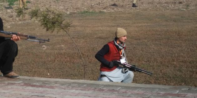 This photograph taken from a mobile phone shows Pakistani security personnel taking position outside the Bacha Khan university following an attack by gunmen in Charsadda, about 50 kilometres from Peshawar, on January 20, 2016. Gunmen have attacked a university in northwestern Pakistan, injuring at least three people, and are still on the rampage, security and school officials told AFP in the latest assault to hit the militant-infested region. AFP PHOTO / A MAJEED / AFP / A Majeed (Photo credit should read A MAJEED/AFP/Getty Images)