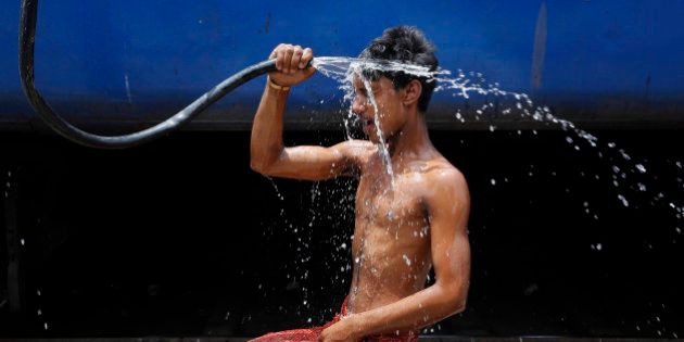 An Indian man takes a shower at a railway station to cool himself down in Allahabad, India, Wednesday, June 10, 2015. Normal life was thrown out of gear in Indiaâs northern state of Uttar Pradesh due to heat wave as temperature in parts of the state breached 47 degrees Celsius (117 degrees Fahrenheit) mark. (AP Photo/Rajesh Kumar Singh)