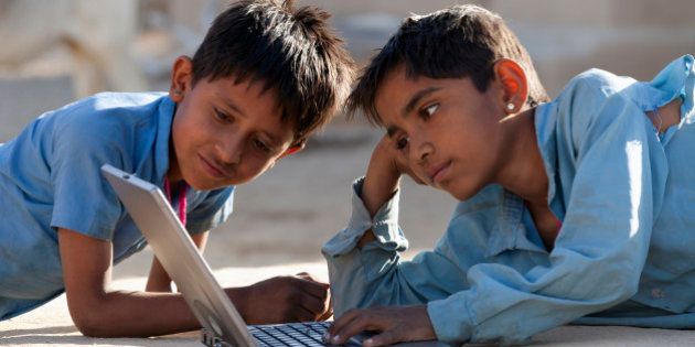 India, Rajasthan, two young boys using laptop computer