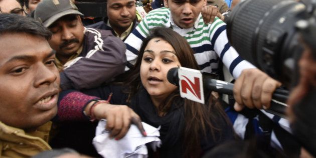 NEW DELHI, INDIA - JANUARY 17: A woman (C) who threw ink on Chief Minister Arvind Kejriwal (Not in Picture) during the thanksgiving event of odd-even scheme at Chhatrasal Stadium on January 17, 2016 in New Delhi, India. The woman identified as Bhavna, claimed to be a member of Aam Aadmi Sena, accused Kejriwal of doing CNG scam. (Photo by Sanjeev Verma/Hindiustan Times via Getty Images)