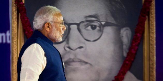 Indian Prime Minister Narendra Modi walks by a photograph of Bhim Rao Ambedkar during the unveiling ceremony of the foundation stone for an international center dedicated to Ambedkar, in New Delhi, India, Monday, April 20, 2015. Ambedkar, an untouchable, or Dalit, and a prominent Indian freedom fighter, was the chief architect of the Indian Constitution, which outlawed discrimination based on caste.(AP Photo/Saurabh Das)