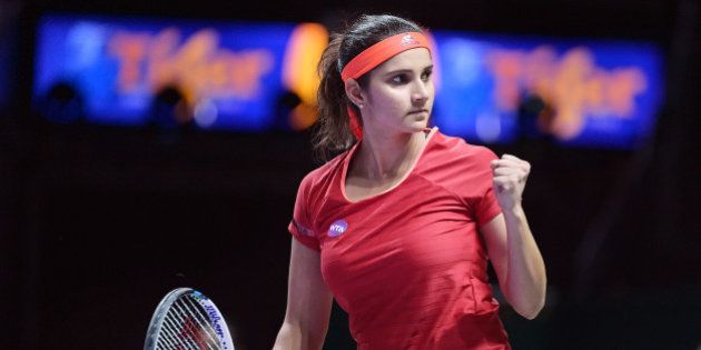 Sania Mirza of India celebrates winning a set with her partner Martina Hingis of Switzerland as they play Timea Babos of Hungary and Kristina Mladenovic of France during their doubles match at the WTA tennis finals in Singapore, Friday, Oct. 30, 2015. (AP Photo/Joseph Nair)