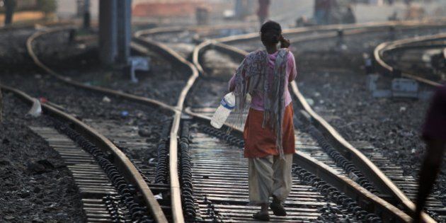 An Indian woman walks after defecating on a railway track, on World Toilet Day in Gauhati, India, Wednesday, Nov. 19 2014. India is considered to have the world's worst sanitation record despite spending some $3 billion since 1986 on sanitation programs, according to government figures. Building toilets in rural India, where hundreds of millions are still defecating outdoors, will not be enough to improve public health, according to a study published last month. (AP Photo/Anupam Nath)