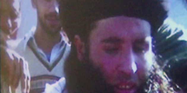 In this image made from video broadcast on Thursday, Nov. 7, 2013, undated footage of Mullah Fazlullah is shown on a projector in Pakistan. Fazlullah, the ruthless commander behind the attack on teenage activist Malala Yousafzai as well as a series of bombings and beheadings, was chosen Thursday as the leader of the Pakistani Taliban, nearly a week after a U.S. drone strike killed the previous chief. (AP Photo via AP Video)