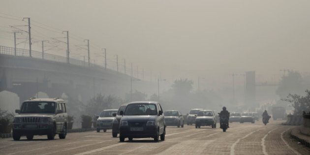 Vehicles move through morning smog on the first day of a two-week experiment to reduce the number of cars to fight pollution in New Delhi, India, Friday, Jan. 1, 2016. The volunteers are meant to encourage people to fall in line with the governmentâs plan to allow private cars on the roads only on alternate days from Jan. 1-15, depending on whether their license plates end in an even or an odd number. (AP Photo/Altaf Qadri)