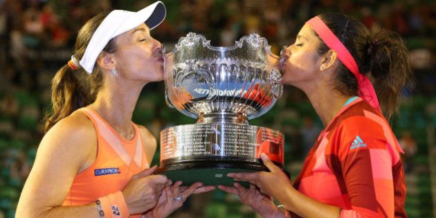 MELBOURNE, AUSTRALIA - JANUARY 29: Martina Hingis of Switzerland and Sania Mirza of India pose with the championship trophy after winning their women's doubles final match against Andrea Hlavackova and Lucie Hradecka of the Czeck Republic during day 12 of the 2016 Australian Open at Melbourne Park on January 29, 2016 in Melbourne, Australia. (Photo by Scott Barbour/Getty Images)