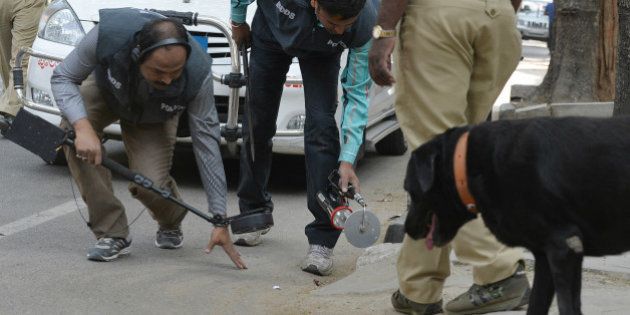 Indian bomb-disposal personnel and police sniffer dogs search an area where an unidentified package was found at the roadside in Bangalore on January 15, 2016. Ppolice later confirmed the incident was a false alarm. AFP PHOTO / Manjunath KIRAN / AFP / MANJUNATH KIRAN (Photo credit should read MANJUNATH KIRAN/AFP/Getty Images)