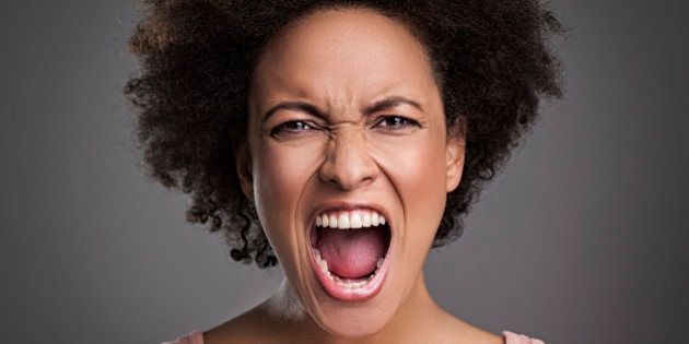 Young African woman shouting angrily.
