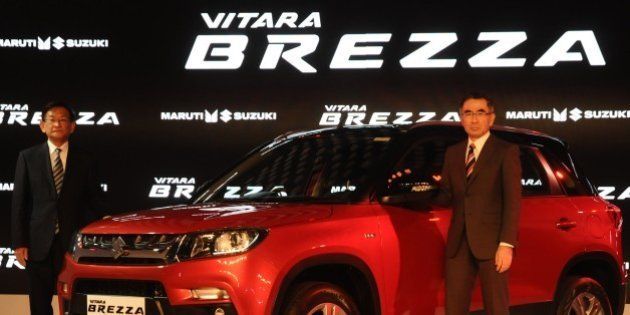 DELHI, INDIA - FEBRUARY 3: Suzuki Motors President Toshihiro Suzuki (R) and Kenichi Ayukawa, Managing Director and CEO of Maruti Suzuki India Ltd., pose with their newly launched Brezza car during the Indian Auto Expo in Greater Noida, on the outskirts of Delhi , February 03, 2016. (Photo by Imtiyaz Khan/Anadolu Agency/Getty Images)