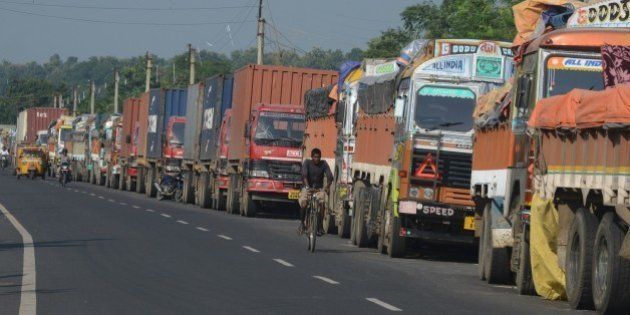 An Indian man cycles past parked Indian trucks carrying goods to Nepal near the India-Nepal border at Panitanki, some 40 kms from Siliguri on September 29, 2015. Nepal's new constitution was meant to end centuries of inequality, but instead it has sparked deadly protests and a trade blockade by ethnic minorities that has forced nationwide fuel rationing. More than 40 people have been killed in clashes between police and protesters representing ethnic minorities who say a new federal structure laid out in the constitution will leave them under-represented in the national parliament. AFP PHOTO / Diptendu DUTTA (Photo credit should read DIPTENDU DUTTA/AFP/Getty Images)