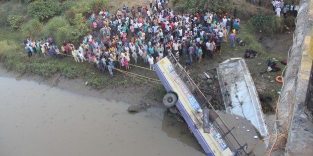 Indian rescue workers and villagers try to extract the injured and dead passengers from a Gujarat State Road Transport Corporation's passenger bus which plunged in to river Purna near Navsari, some 315 kms from Ahmedabad on February 5, 2016. packed passenger bus plunged off a bridge into a river in western India Friday killing at least 37 people, an official said, in one of the deadliest road accidents in recent years. / AFP / STR (Photo credit should read STR/AFP/Getty Images)