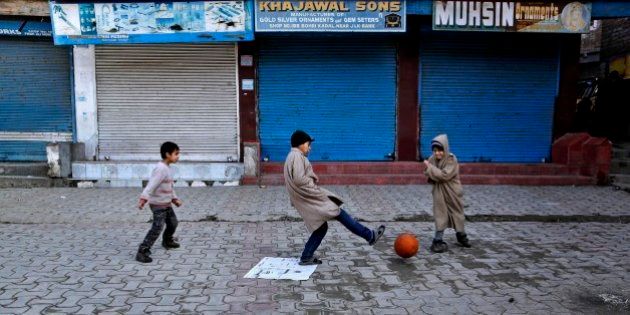 Kashmiri children play soccer at a closed market during a strike in Srinagar, India, Monday, Feb. 9, 2015. Hundreds of armed police and paramilitary soldiers are patrolling the disputed region of Kashmir where anti-India separatists called a strike to protest the secret execution two years ago of a former Kashmiri rebel and medical student Mohammed Afzal Guru. Many in this mostly Muslim region believe Guru was not given a fair trial on charges of involvement in 2001 Parliament attack that killed 14 people, including five gunmen. (AP Photo/Mukhtar Khan)