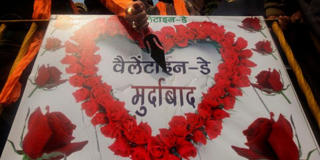 An activist of right wing Shiv Sena pokes a knife into a placard with an anti-valentine's day message during a protest in Amritsar, India, Monday, Feb. 13, 2012. Protests by groups like Shiv Sena which says it is defending traditional Indian values from Western promiscuity have become an annual event during Valentine's Day which falls on Feb.14. The placard in Hindi reads