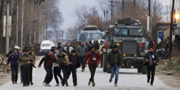 Kashmiri residents run to safety after being rescued from a building taken over by suspected militants during clashes in the Sempora area of Pampore, some 15 kms south of Srinagar on February 20, 2016. Gunmen attacked a paramilitary convoy in restive Indian-administered Kashmir February 20, killing two soldiers before entering a government-run training institute with 100 people inside, police said, with firing still ongoing. The militants, believed to be rebels opposed to Indian rule, assaulted a Central Reserve Police Force (CRPF) convoy before paramilitaries engaged them in a firefight in the complex on the outskirts of Srinagar. AFP PHOTO / STR / AFP / STRDEL (Photo credit should read STRDEL/AFP/Getty Images)