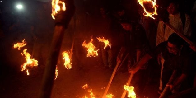 Indian Leftist student activists carry torches and shout slogans against the Bharatiya Janata Party (BJP)-led union government during a protest near Jadavpur Unversity on February 23, 2016. A bitter row over a student's arrest for sedition at a prestigious Indian university has exposed deep divisions between liberal intellectuals and the nationalist government in the world's biggest democracy. Student union leader Kanhaiya Kumar is accused of shouting 'anti-India slogans' during a rally at Jawaharlal Nehru University (JNU) in New Delhi to mark the anniversary of the execution of a Kashmiri separatist leader. Thousands of students and teachers have since protested around the country against his arrest, accusing Prime Minister Narendra Modi's Hindu nationalist government of misusing the British-era sedition law to stifle dissent. AFP PHOTO / Dibyangshu SARKAR / AFP / DIBYANGSHU SARKAR (Photo credit should read DIBYANGSHU SARKAR/AFP/Getty Images)