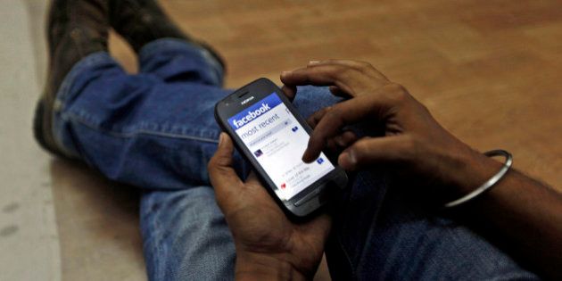 A man surfs the Facebook site on his mobile phone in Mumbai, India, Friday, May 18, 2012 . Facebook's stock is set to begin trading on the Nasdaq Stock Market on Friday, the day after the world's definitive online social network raised $16 billion in an initial public offering that valued the company at $104 billion. (AP Photo/ Rajanish Kakade)