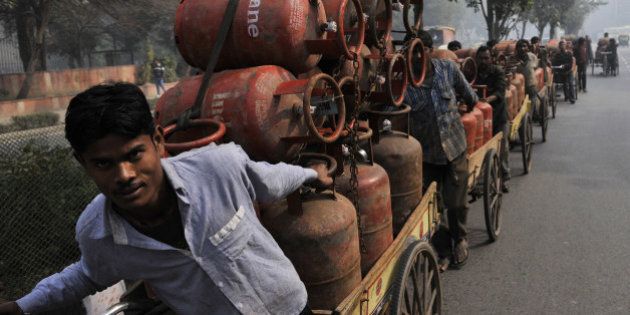 NEW DELHI INDIA JANUARY 30: LPG cooking gas cylinder vendors transferring cylinders on a cart from a warehouse on January 30, 2014 in New Delhi, India. Cabinet approves raising ceiling on subsidized cooking gas cylinders from 9 to 12. (Photo by Vipin Kumar/Hindustan Times via Getty Images)