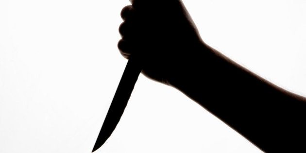 A silhouette of a hand holding a knife