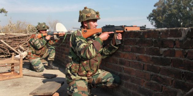 Indian army soldiers take positions on a rooftop of a building outside the Indian airbase in Pathankot, 430 kilometers (267 miles) north of New Delhi, India, Saturday, Jan. 2, 2016. At least four gunmen entered an Indian air force base near the border with Pakistan on Saturday morning and exchanged fire with security forces, leaving two of them dead, officials said. (AP Photo/Channi Anand)
