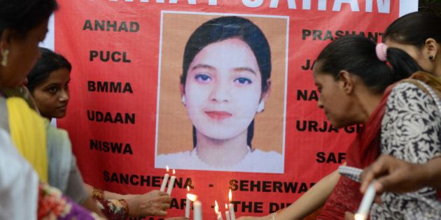 Supporters hold candles in front of a banner bearing the portrait of Ishrat Jahan during a protest in Ahmedabad on July 6, 2013. The protest was organised to demand justice for Ishrat Jahan, who was killed along with three others by the Gujarat police in a fake encounter in June 2004, and according to the Indian Central Beurau of Investigation (CBI) was not a terrorist. AFP PHOTO / Sam PANTHAKY (Photo credit should read SAM PANTHAKY/AFP/Getty Images)