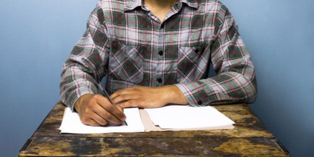 Young man writing at desk
