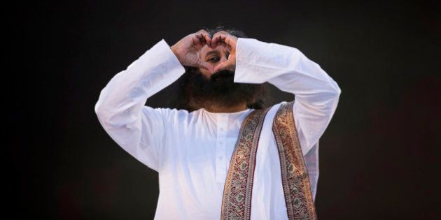 India's spiritual leader and founder of Art of Living Foundation Sri Sri Ravi Shankar looks to the crowd through a heart formed with his hands before leading a meditation with thousands of participants in Buenos Aires, Argentina, Sunday, Sept. 9, 2012. (AP Photo/Natacha Pisarenko)