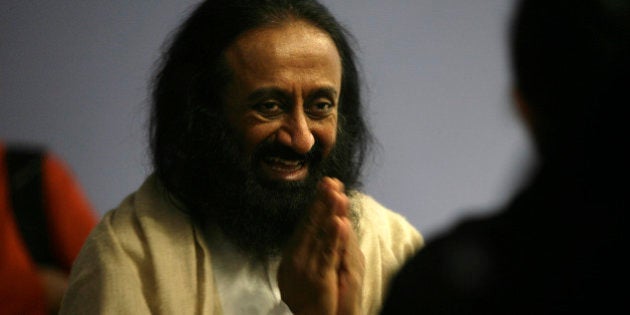 Indian spiritual leader, humanitarian and teacher, Sri Sri Ravi Shankar greets a member of the audience gathered in Milnerton, Cape Town, on August 28, 2012. Sri Sri Ravi Shankar is the founder the Art of Living Foundation AFP PHOTO / MARK WESSELS (Photo credit should read Mark Wessels/AFP/GettyImages)