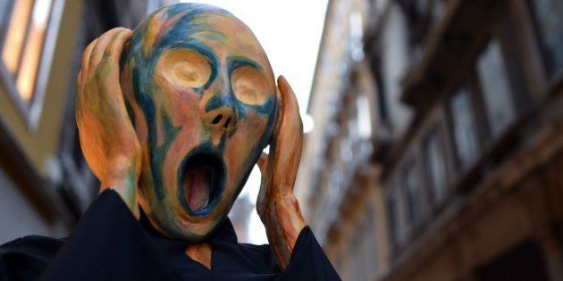 A costumed reveller wearing a mask depicting Munch's famous painting 'The Scream' poses near St Mark's square during the carnival on February 21, 2014 in Venice. The 2014 edition of the Venice carnival is untitled ' Wonder and fantasy nature' and runs from February 15 to March 4, 2014. AFP PHOTO / GABRIEL BOUYS (Photo credit should read GABRIEL BOUYS/AFP/Getty Images)