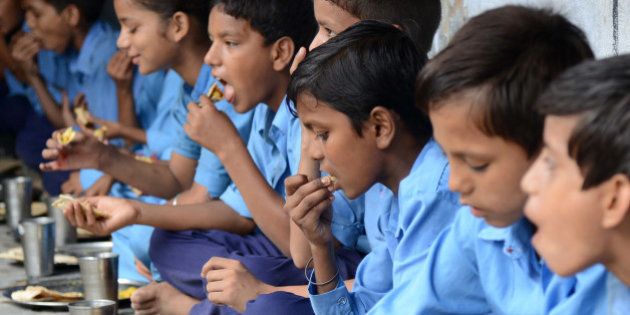 Indian schoolchildren eat their free mid-day meal at a government school in Amritsar on July 19, 2013. Punjab state Education Minister Sikander Singh Maluka issued directions to all authorities concerned to observe hygiene regulations in serving the mid-day meal and said all principals and heads of schools would be held personally accountable for any discrepancies in the service. Twenty-three children died on July 17, after eating a free lunch feared to contain poisonous chemicals at a school in thee eastern Indian state of Bihar. AFP PHOTO/NARINDER NANU (Photo credit should read NARINDER NANU/AFP/Getty Images)