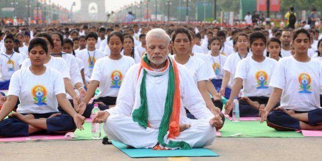 NEW, DELHI - INDIA: Indian Prime Minister Narendra Modi (C) performs yoga along with others at Rajpath during mass yoga session to mark the International Day of Yoga on June 21, 2015 in New Delhi, India. An estimated 40,000 people participated in the celebrations at Rajpath, with around two billion people taking part across the world. The yoga celebrations are being organised after the United Nations had in December last year declared June 21 as International Yoga Day. (Photo by Vinod Singh/Anadolu Agency/Getty Images)