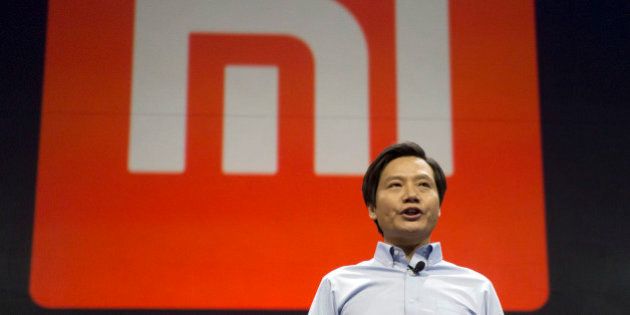 Xiaomi Chairman Lei Jun stands in front of the logo of the Chinese smartphone maker, at a press event in Beijing, Thursday, Jan. 15, 2015. The Chinese manufacturer on Thursday unveiled a new model that Lei said has processor size and performance comparable to Appleâs iPhone 6 but is thinner and lighter. (AP Photo/Ng Han Guan)