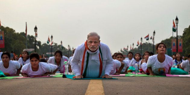 Indian Prime Minister Narendra Modi lies down on a mat as he performs yoga along with thousands of Indians on Rajpath, in New Delhi, India, Sunday, June 21, 2015. Millions of yoga enthusiasts are bending their bodies in complex postures across India as they take part in a mass yoga program to mark the first International Yoga Day.(AP Photo/Saurabh Das)