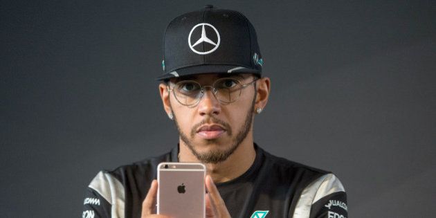 Lewis Hamilton, piloto de la FÃ³rmula Uno, observa su iPhone durante una conferencia de prensa en Fellbach, Alemania, el viernes 11 de marzo de 2016 (Marijan Murat/dpa via AP)