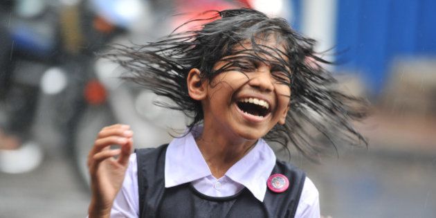 An Indian child shakes her hair during a heavy downpour of rain as she waits for transport outside her school in Hyderabad on August 19, 2011. Monsoon rains are a key factor for global commodities markets, strengthening the output of various crops in India, which could help bring relief to Asia's third-largest economy in its battle with high food prices. AFP PHOTO/Noah SEELAM (Photo credit should read NOAH SEELAM/AFP/Getty Images)