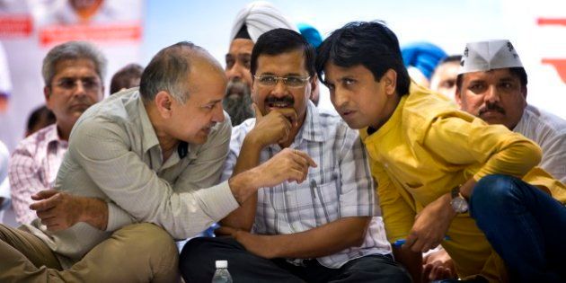 Delhi Chief Minister Arvind Kejriwal sits flanked by Aam Aadmi Party or Common manâs party leaders Manish Sisodia, left and Kumar Vishwas at a farmerâs rally near the Indian parliament in New Delhi, India, Wednesday, April 22, 2015. Indian farmers and the opposition parties are protesting against a government plan to ease rules for obtaining land for industry and development projects. (AP Photo/Saurabh Das)