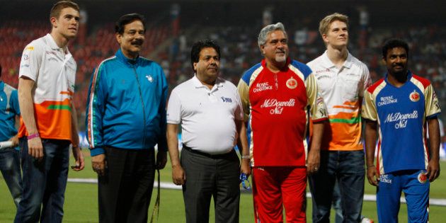 Pune Warriors team owner Subroto Roy, second left, and Royal Challengers Bangalore team owner Vijay Mallya, third right, stand with Indian Premier League (IPL) Chairman Rajiv Shukla, third left, cricketer Muttaiah Muralitharan, right, and Sahara Force India drivers Paul di Resta, left, and Nico Hulkenberg, second right, before the start of the IPL cricket match between Pune Warriors and Royal Challengers Bangalore in Bangalore, India, Tuesday, April 17, 2012. (AP Photo/Aijaz Rahi)