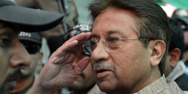 Former Pakistani president Pervez Musharraf (C) is escorted by soldiers as he salutes on his arrival at an anti-terrorism court in Islamabad on April 20, 2013. A Pakistani anti-terrorism court on April 20 extended former military ruler Pervez Musharraf judicial remand to prison for two weeks for sacking judges during his rule, officials said. AFP PHOTO / AAMIR QURESHI (Photo credit should read AAMIR QURESHI/AFP/Getty Images)