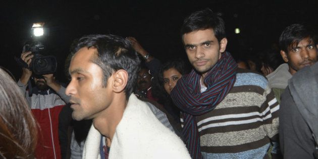 This photograph taken late on February 23, 2016 shows Indian student activist Umar Khalid (C) and Anirban Bhattacharya (L) walking through the campus of New Delhi's Jawaharlal Nehru University (JNU) on their way to surrendering to Indian authorities. Khalid and Bhattacharya are accused of sedition over a rally at which anti-India slogans were shouted. Students have accused Prime Minister Narendra Modi's right-wing nationalist government of misusing the British-era sedition law to stifle dissent. AFP PHOTO / AFP / STRDEL (Photo credit should read STRDEL/AFP/Getty Images)