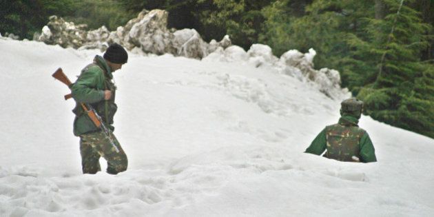 Indian Army soldiers patrol near the Jammu-Srinagar highway in Patnitop, about 110 kilometers (69 miles) northeast of Jammu, India, Wednesday, march 2, 2005. The highway connecting Kashmir to the rest of India reopened Tuesday after being blocked for three weeks by heavy snowfall, landslides and avalanches that left at least 310 people dead on the Indian side of the Himalayan territory, police said. (AP Photo/Channi Anand)