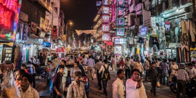 Delhi, India - October 11, 2015: People walking in Main Bazaar street of Paharganj at night Delhi India. This neighbourhood of Central Delhi is well known as a commercial area and also were hundreds of affordable hostels, restaurants and hotels are located.