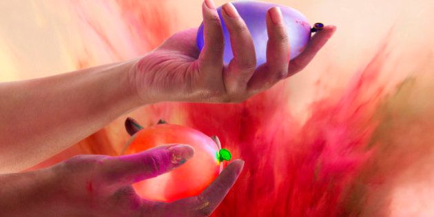 Close-up of hands holding water bombs during Holi festival