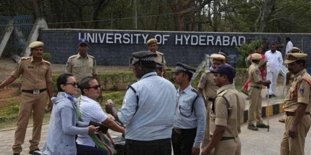Policemen stand guard as security men check the identity cards of students arriving at the Hyderabad University in Hyderabad, in India, Tuesday, Jan 19, 2016. Hundreds of students on Tuesday angrily protested the death of an Indian student who, along with four others, was barred from using some facilities at his university in the southern tech-hub of Hyderabad. The protesters accused Hyderabad University's vice chancellor along with a federal minister of unfairly demanding punishment for the five lower-caste students after they clashed last year with a group of students supporting the governing Hindu nationalist party. (AP Photo /Mahesh Kumar A.)