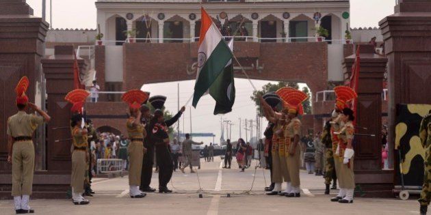 Pakistani Rangers and Indian Border Security Force personnel lower their respective country flags at the Beating Retreat Ceremony at the India-Pakistan Wagah Border Post on March 24, 2016. / AFP / NARINDER NANU (Photo credit should read NARINDER NANU/AFP/Getty Images)
