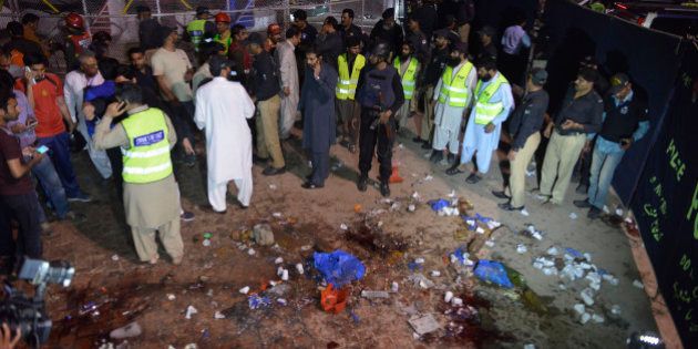 Pakistani rescuers and officials gather at a bomb blast site in Lahore on March 27, 2016.At least 25 people were killed and dozens injured when an explosion ripped through the parking lot of a crowded park where many minority Christians had gone to celebrate Easter Sunday in the Pakistani city Lahore, officials said. / AFP / ARIF ALI (Photo credit should read ARIF ALI/AFP/Getty Images)