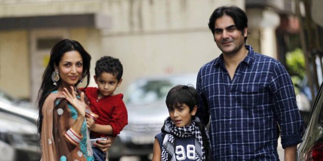 Indian Bollywood film actor Malaika Arora Khan (L), with husband Arbaz khan and sons, greets well-wishers outside her residence during Eid al-Fitr in Mumbai on August 20, 2012. AFP PHOTO (Photo credit should read STR/AFP/GettyImages)