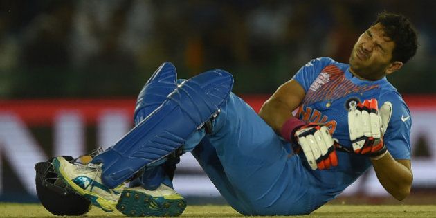 India's Yuvraj Singh grimaces in pain during the World T20 cricket tournament match between India and Australia at The Punjab Cricket Stadium Association Stadium in Mohali on March 27, 2016. / AFP / MONEY SHARMA (Photo credit should read MONEY SHARMA/AFP/Getty Images)