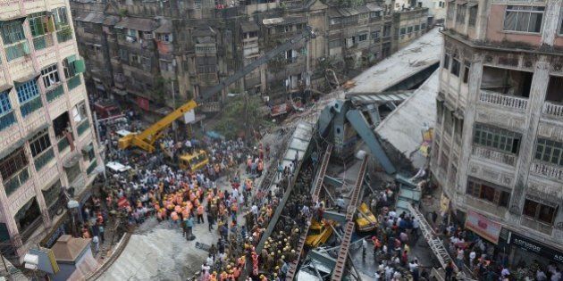 Indian rescue workers and volunteers try to free people trapped under the wreckage of a collapsed fly-over bridge in Kolkata on March 31, 2016.At least 14 people were killed and dozens more injured when a flyover collapsed in a busy Indian city on March 31, an official said, as emergency workers battled to rescue people trapped under the rubble. / AFP / Dibyangshu SARKAR (Photo credit should read DIBYANGSHU SARKAR/AFP/Getty Images)