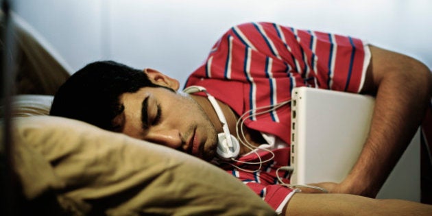 Young Man Hugging Laptop in Sleep